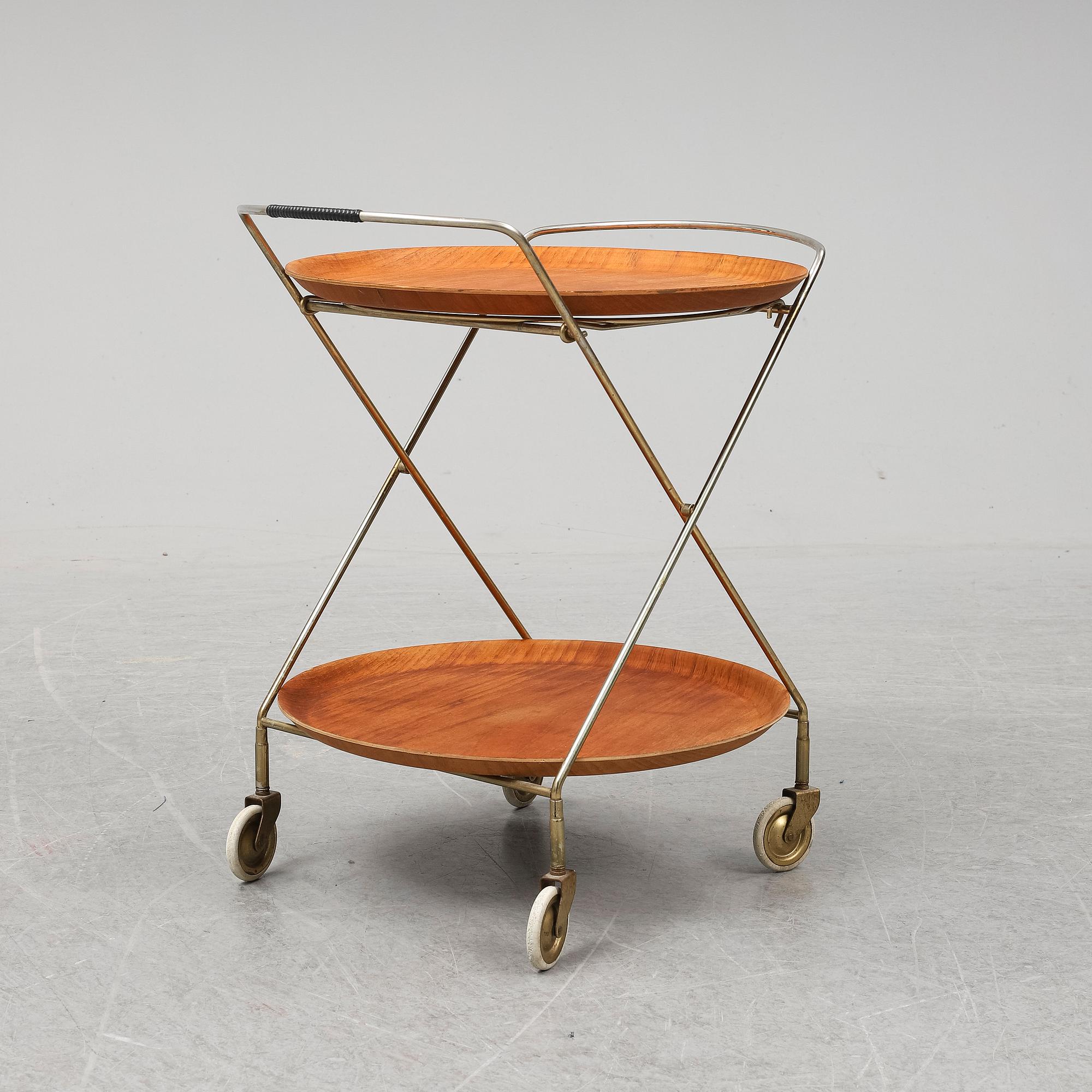 A drinks trolley from J-H Fabrikerna, Sävsjö, 1960-tal.Två lösa, runda brickor fanerade med teak. Märkta J-H Fabrikerna.
