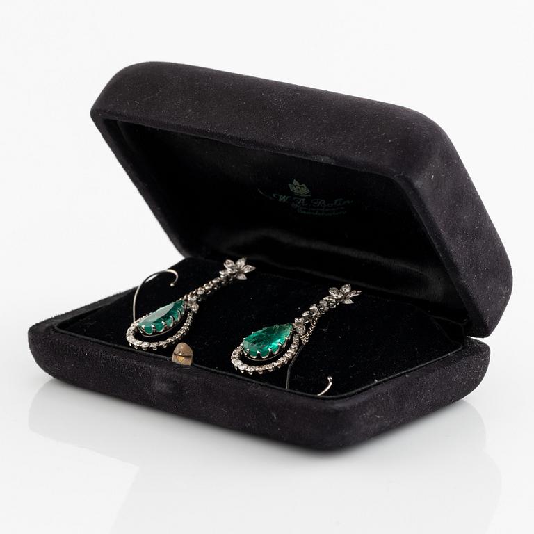 Ett par örhängen, med droppformade smaragder och diamanter.