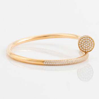 A Cartier "Juste un Clou" bracelet in 18K gold set with round brilliant-cut diamonds.