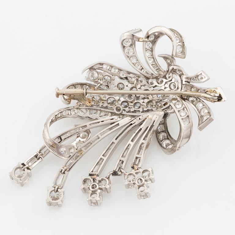 A platinum brooch with round brilliant and baguette-cut diamonds.