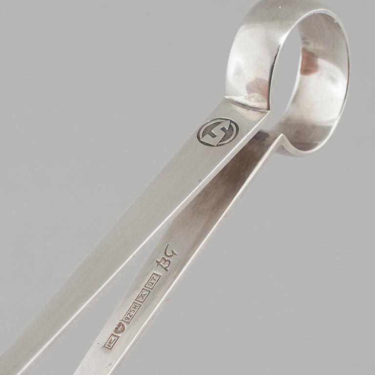 Two silver drink accessories with finnish stamps.