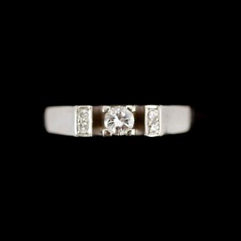 RING, 18 k vitguld, med en större och 4 mindre briljanter, 0.14 ct enligt gravyr. Total vikt ca 3 gram.