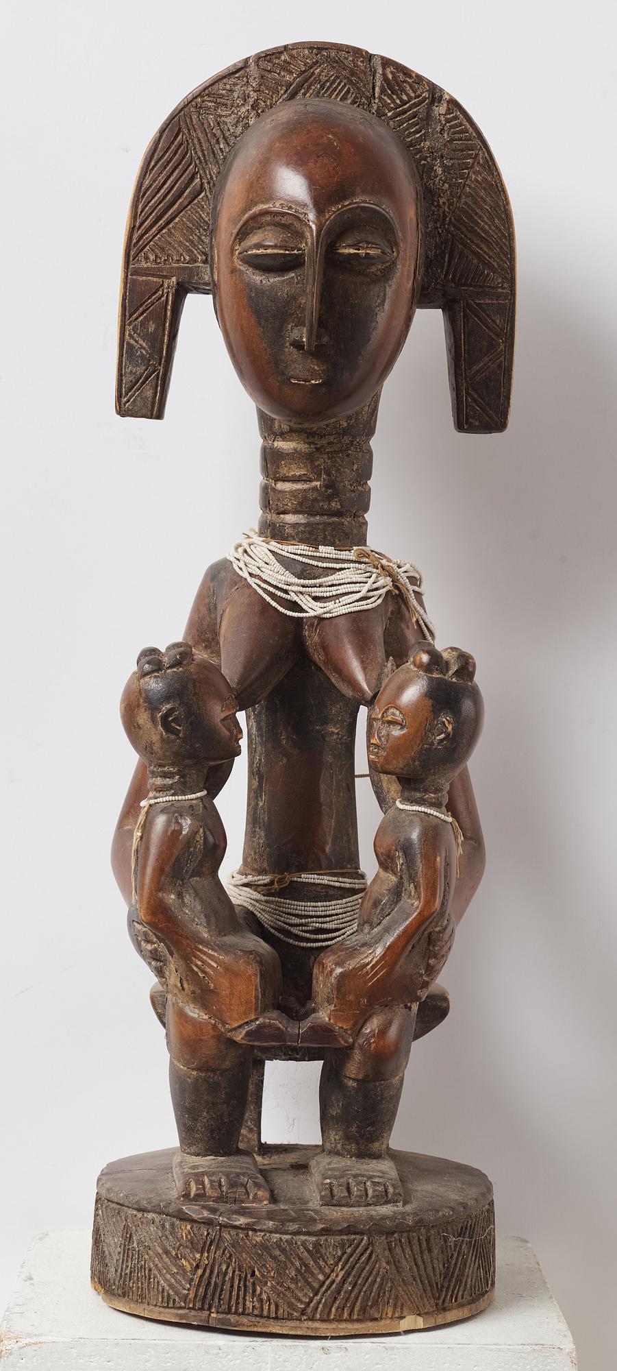 A sculptue and two masks reportedly from The Ivory coast, from the second half of the 20:th century.