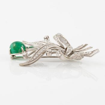 A brooch in 18K white gold with a cabochon-cut emerald.
