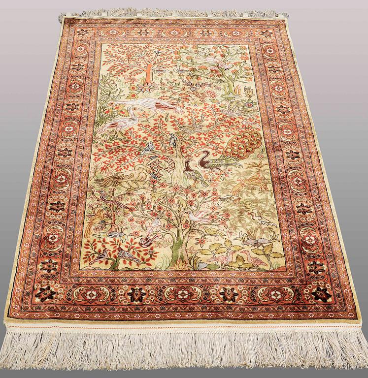 An Oriental figural silk rug, ca 126 x 83 cm.