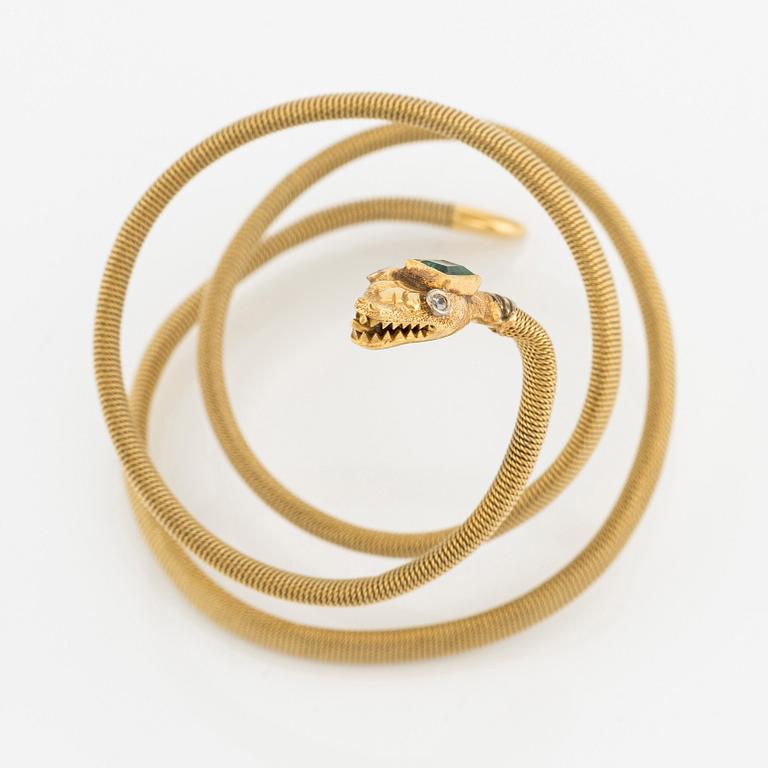 An 18K gold snake bracelet with an emerald and eight-cut diamonds.