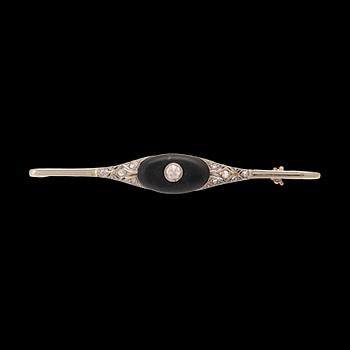 A 14K white and red gold brooch set with round brilliant-cut and rose-cut diamonds and a black stone.