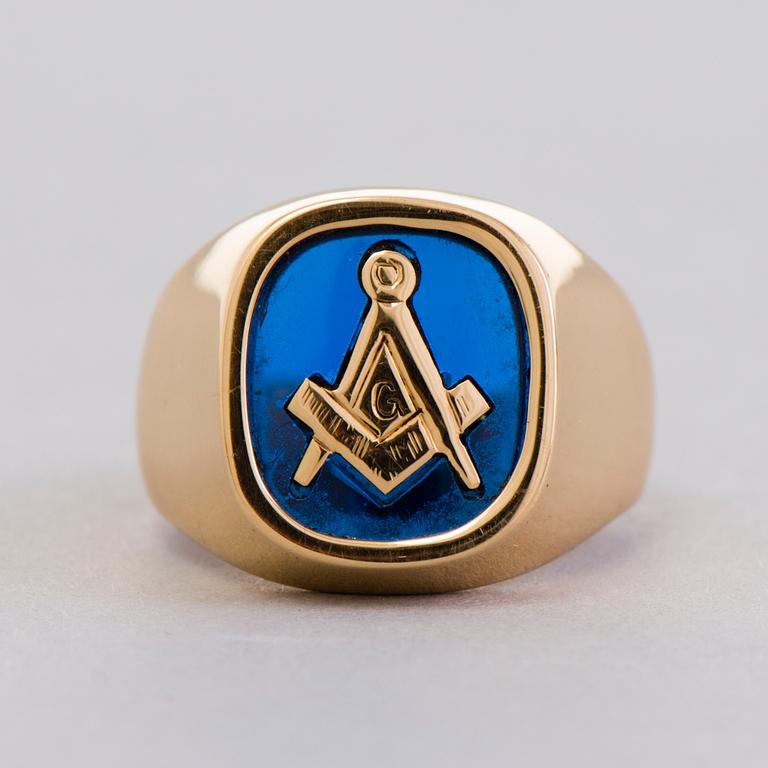 A gold 18K Freemason ring with a synthetic blue sapphire.