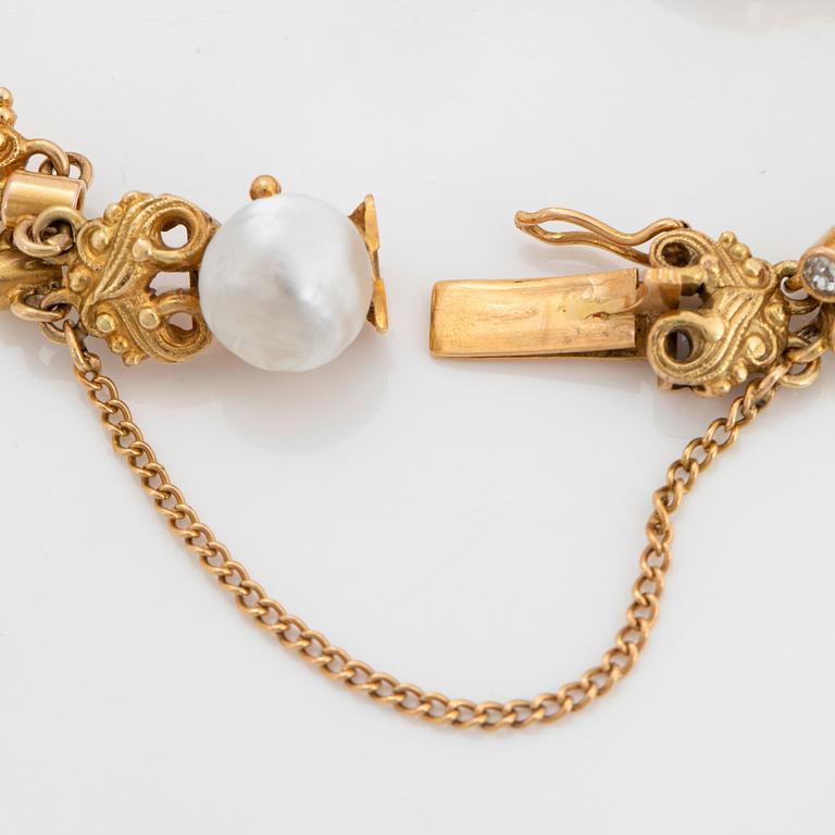 A 14K gold bracelet set with pearls, possibly natural, and old-cut diamonds.