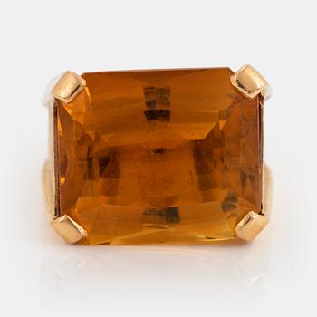 883. An 18K gold ring set with a faceted citrine.