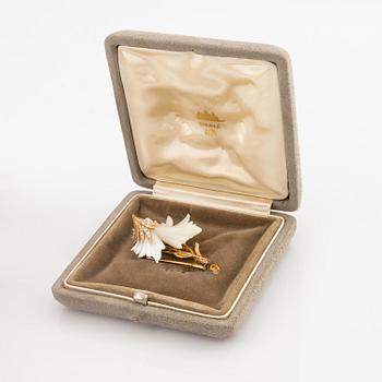 A Sterlé flower brooch in 18K gold and mother-of-pearl set with round brilliant-cut diamonds.