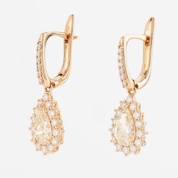 A pair of earrings in 18K gold with two drop-shaped brilliant-cut diamonds.