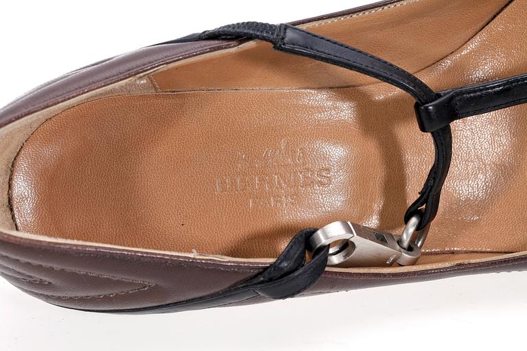 A pair of brown and black leather shoes by Hermès.