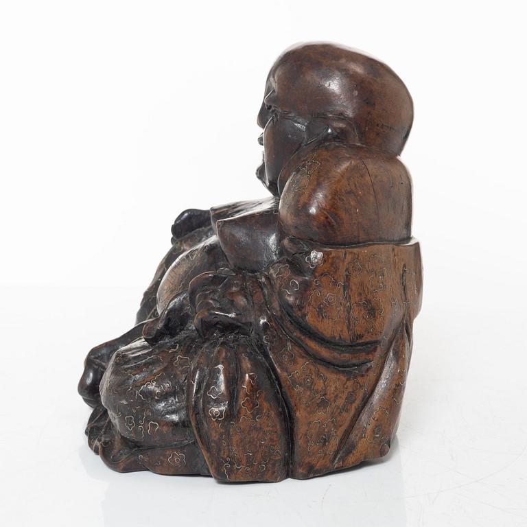 A Chinese wooden figure of Budai with silver inlays, Qing dynasty (1644-1912).