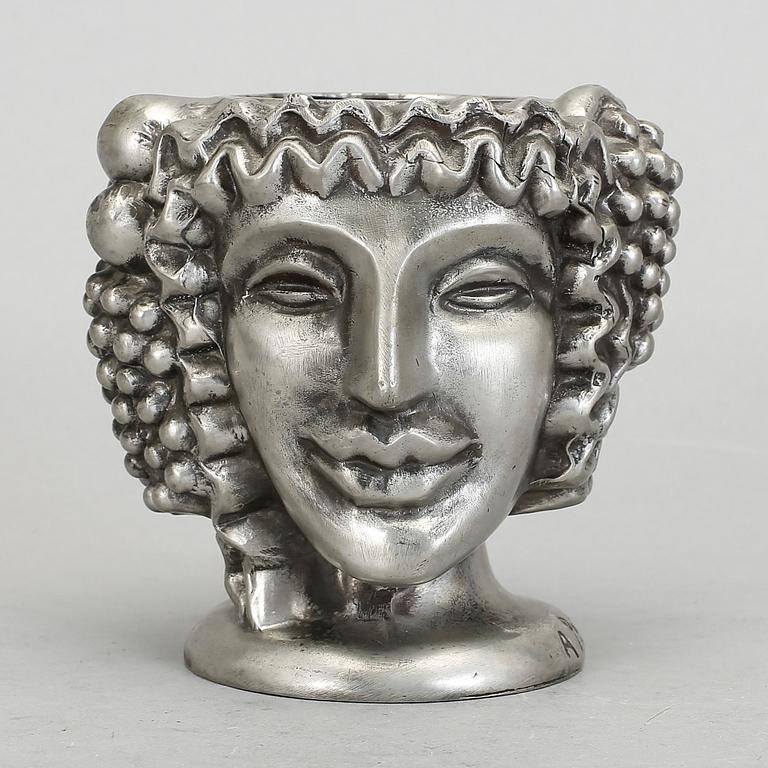 VAS, tenn, "Janushuvud", formgiven av Anna Petrus, Firma Svenskt Tenn, Stockholm, 1957.