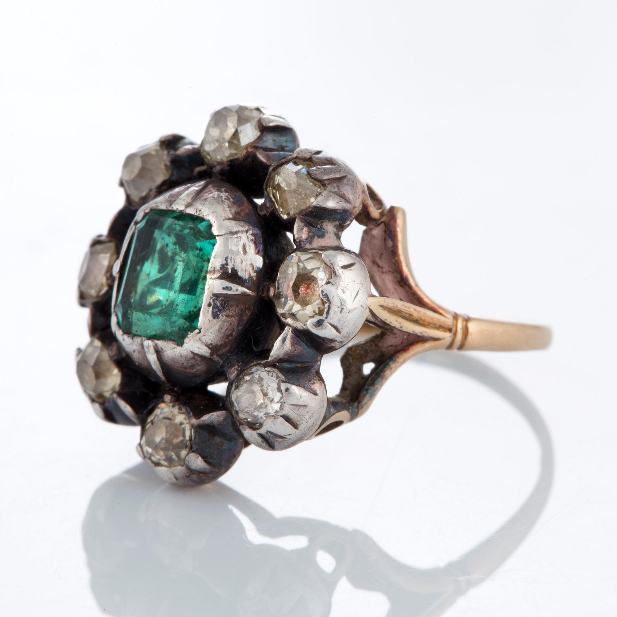 A ring set with an emerald and old-cut diamonds.