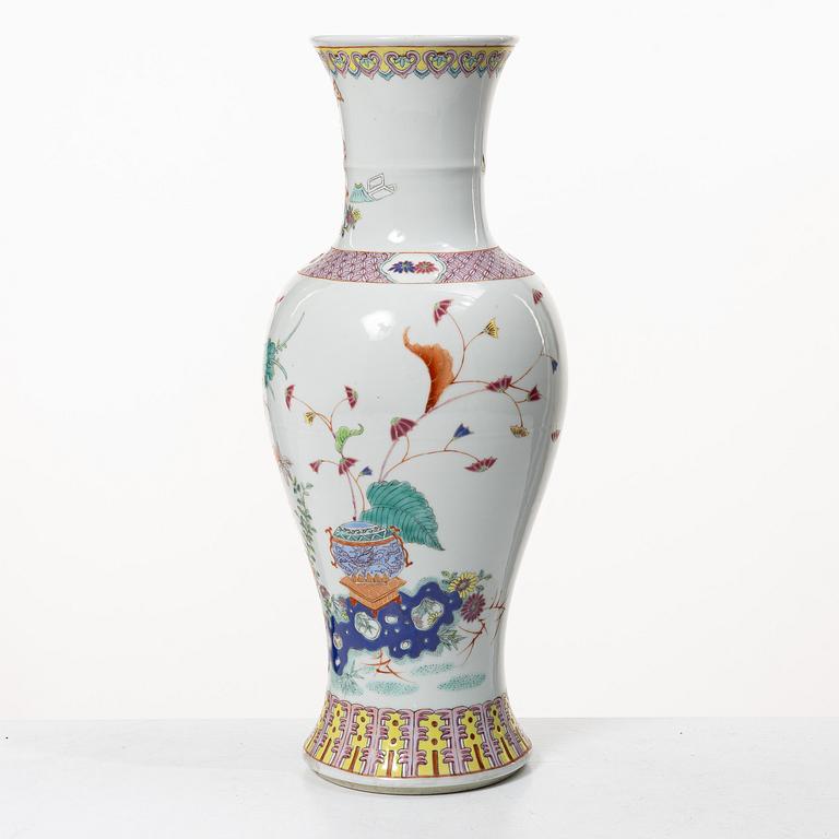 A slender famille rose 'flowers and antiques' vase, late Qing dynasty/early 20th century.