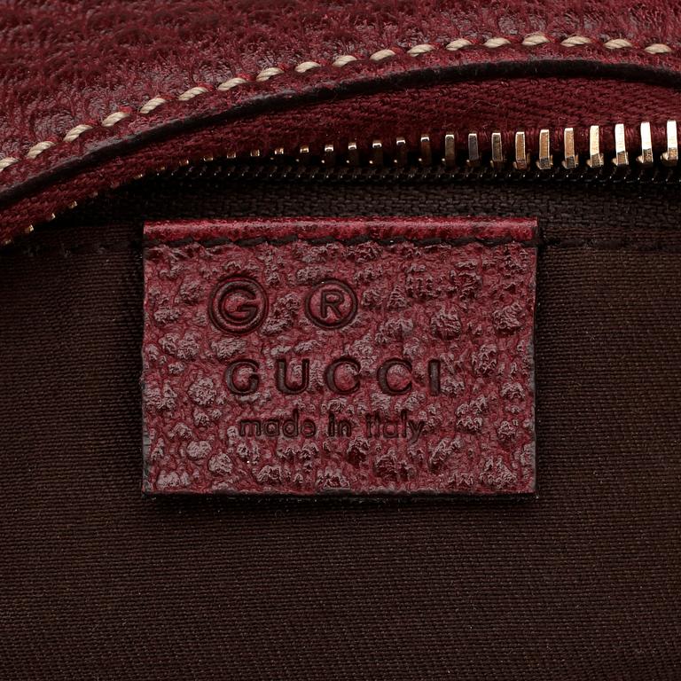 GUCCI, a dark burgundy red shoulder bag.