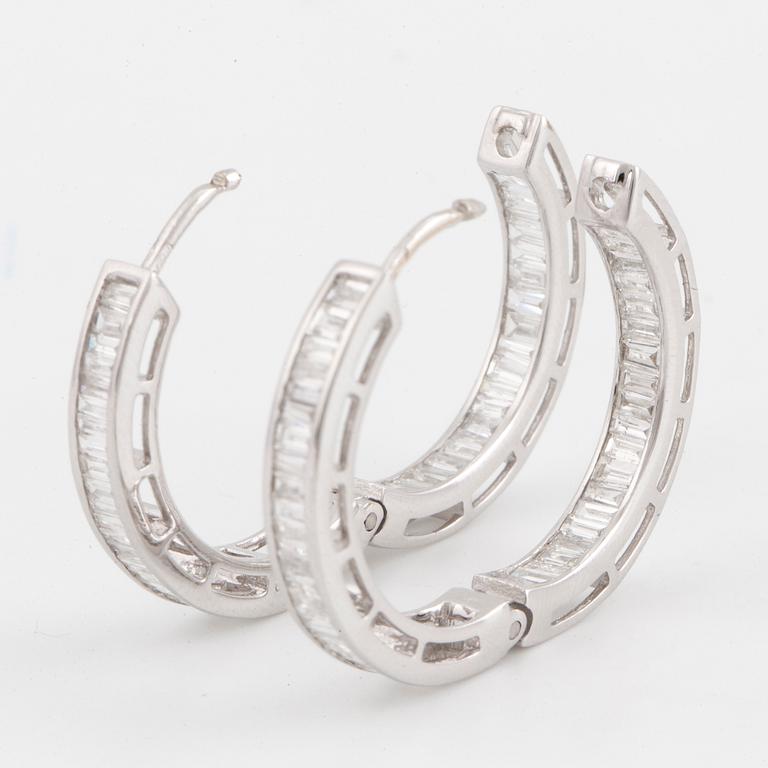 18K white gold and baguette-cut diamond hoop earrings.