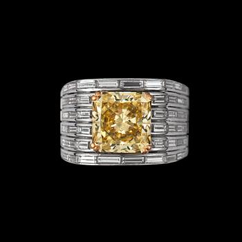 1099. A fancy yellow diamond ring, according to certificate 4.13 cts, and 52 tapered baguette-cut diamonds tot. 1.69 cts.