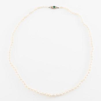 Necklace with graduated cultured pearls, clasp in 18K white gold set with a cabochon-cut emerald.