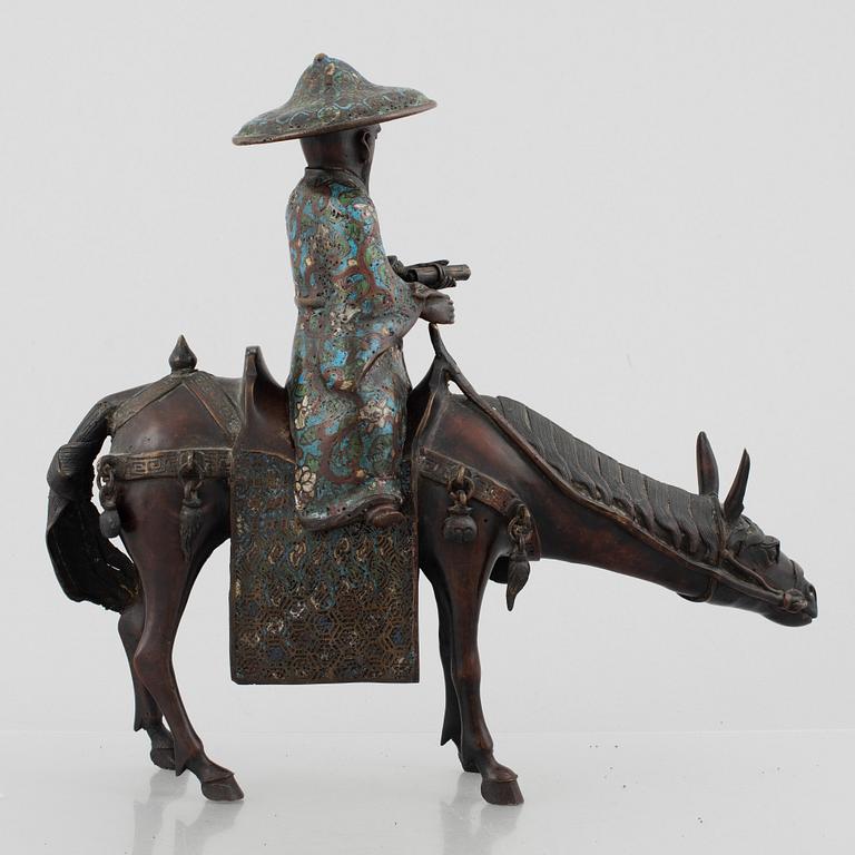 A Chinese bronze and cloissoné figurine on a mule, late Qing/early 20th century.