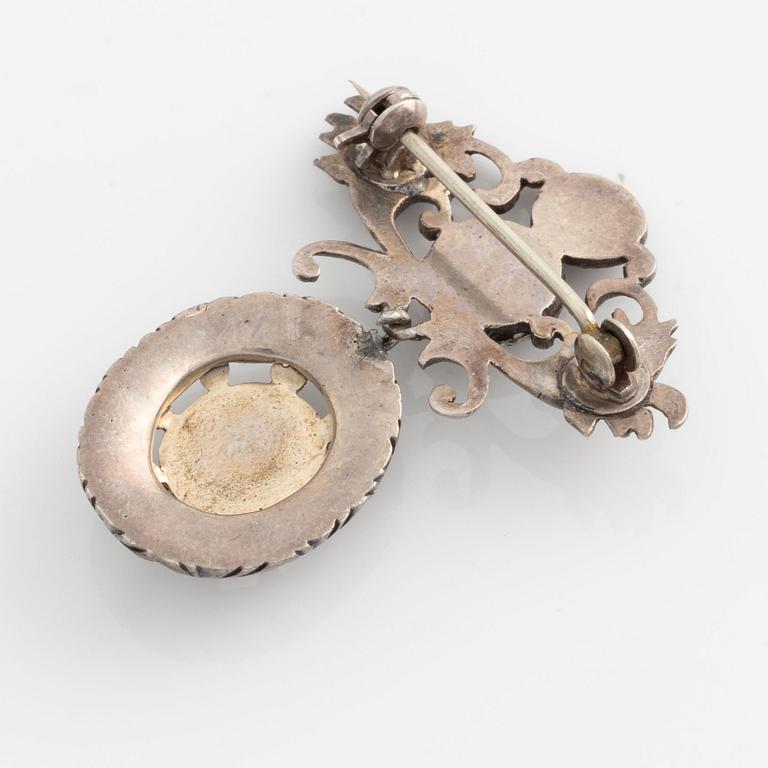 Silver brooch with emeralds and rubies.