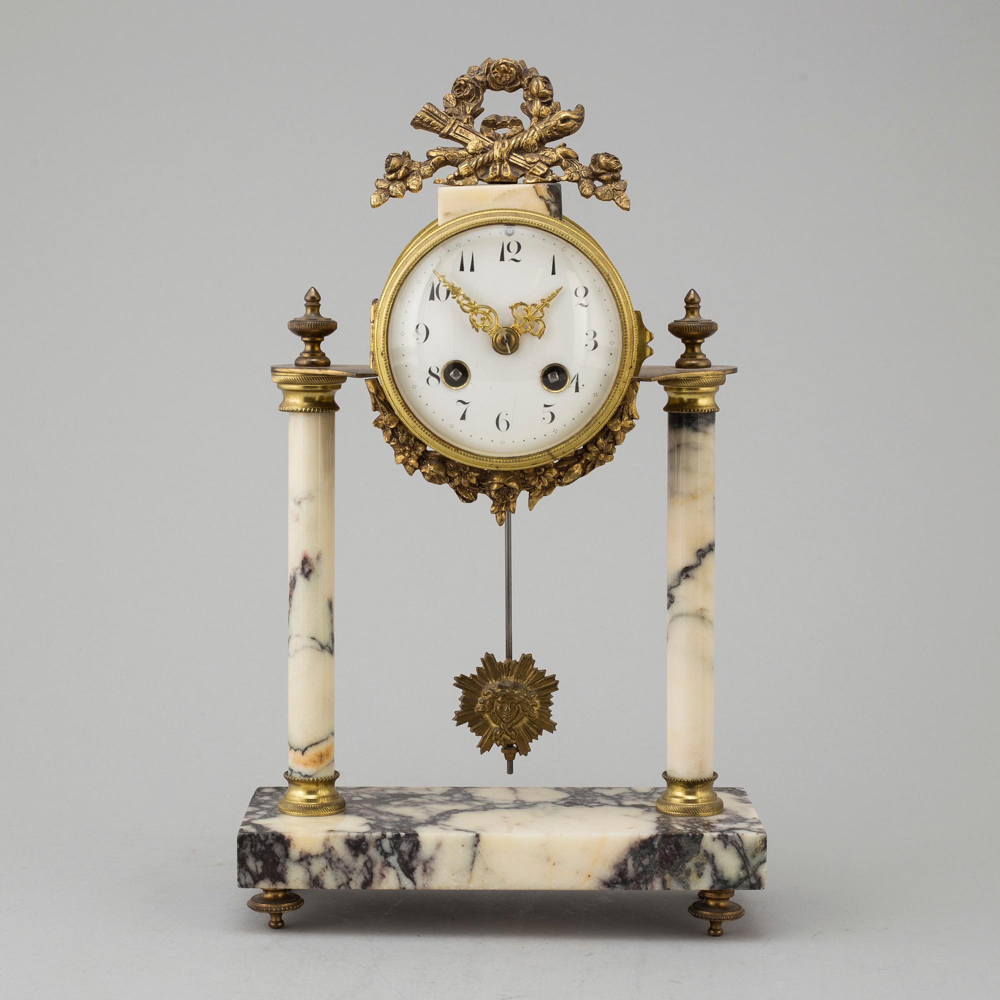 A marble and brass pendulum clock, first half of the 20th century.
