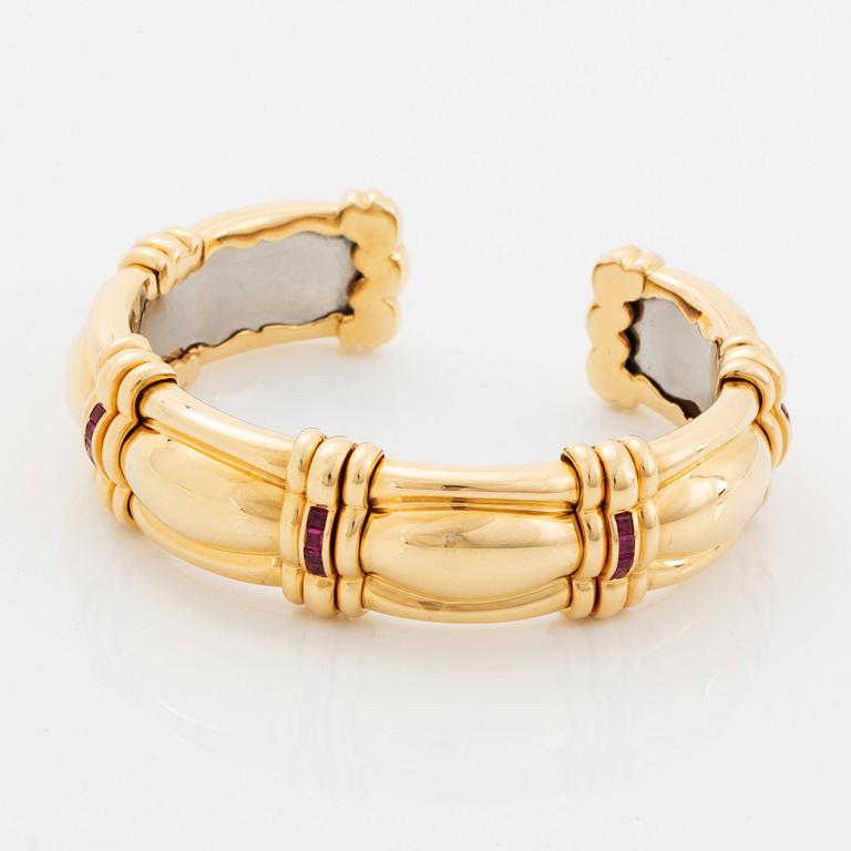 An 18K gold bracelet set with step-cut rubies.