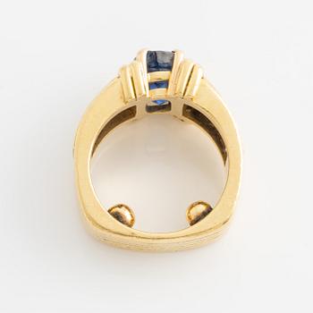 Ring in 18K gold set with an oval faceted sapphire and princess-cut diamonds.