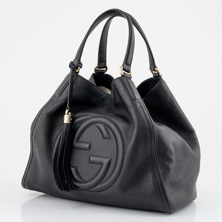 Gucci, a black leather handbag.