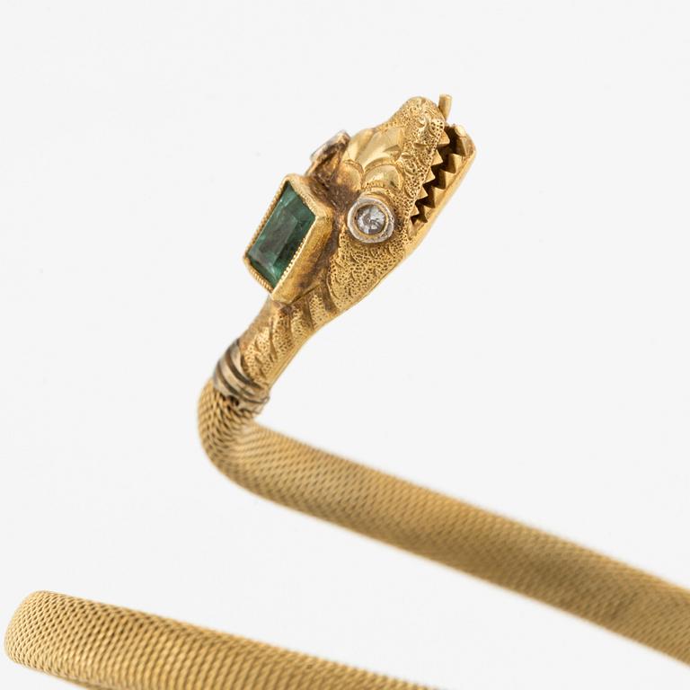 An 18K gold snake bracelet with an emerald and eight-cut diamonds.