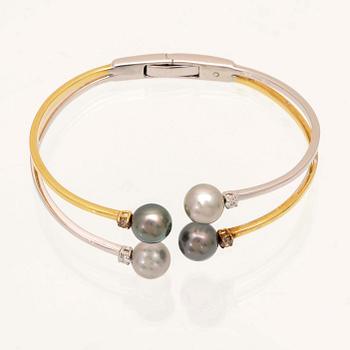 An 18K white- and yellow gold bracelet with round brilliant cut diamonds and cultured Tahitian pearls, Damiani Italy.