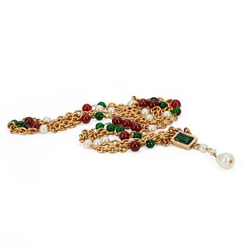 407. CHANEL, a long gold colored necklace with green and red glass beads as wells as white decorative pearls, not marked.