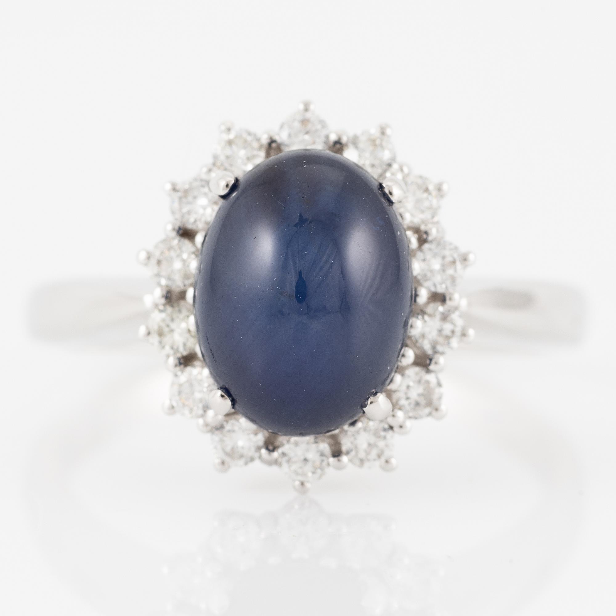 Ring in 18K white gold set with a cabochon-cut sapphire and brilliant-cut diamonds.