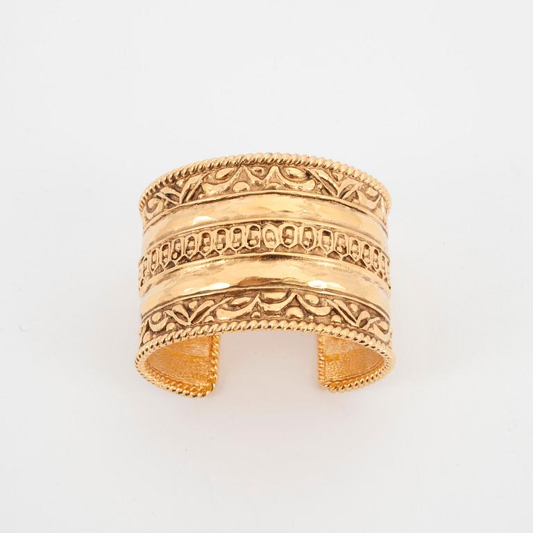 CHANEL, a gold colored metal cuff braclet.
