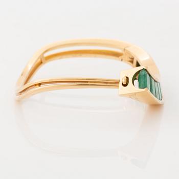 An 18K gold Lantz bracelet set with step-cut emeralds.