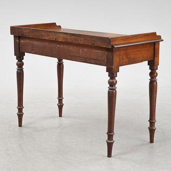 A mahogany writing desk with an armchair, 19th Century.