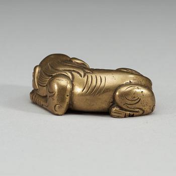 A bronze paper-weight modeled as a reclining lion, Qing dynasty, presumably 18th Century.