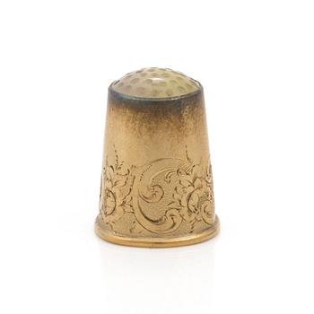 An 18K gold thimble.