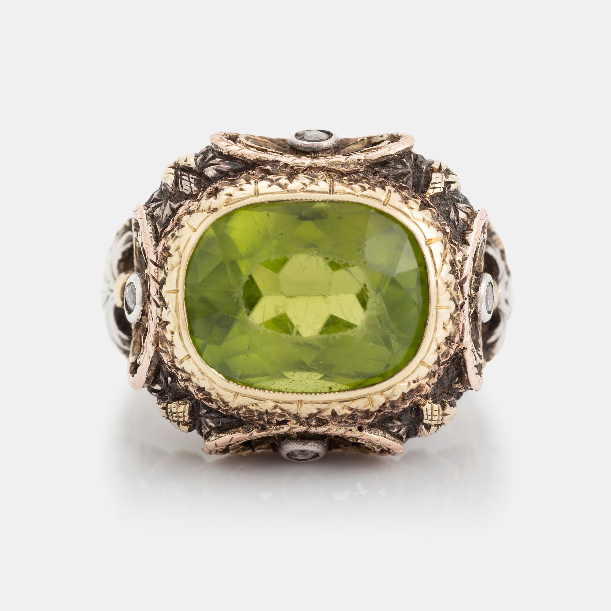 A silver and gold ring set with a faceted peridot and rose-cut diamonds.