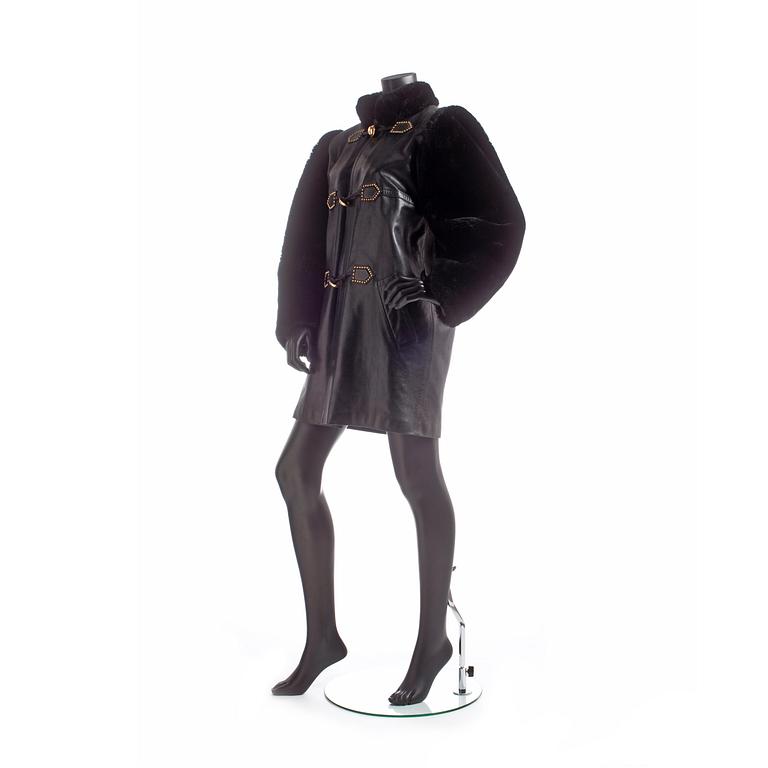 YVES SAINT LAURENT, a black lamb leather coat with fur details.
