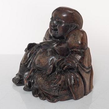 A Chinese wooden figure of Budai with silver inlays, Qing dynasty (1644-1912).