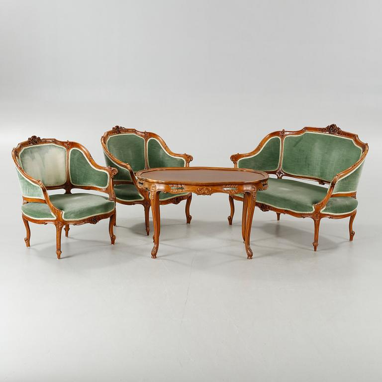 A rococo style sofa, two lounge chairs and a table, around the year 1900 and first half of the 20th century.