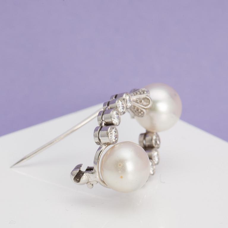 A ca 0.40 ct brilliant-cut diamond brooch with two freshwater pearls.