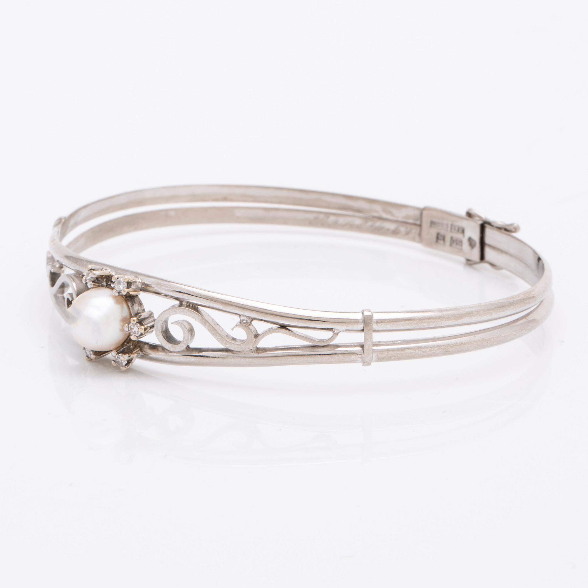 Armring 18K vitguld 1 odlad pärla ca 7,5 mm och 6 diamanter 8/8, stämplad K HIL Helge Larsson Malmö 1966, ca 16 cm.
