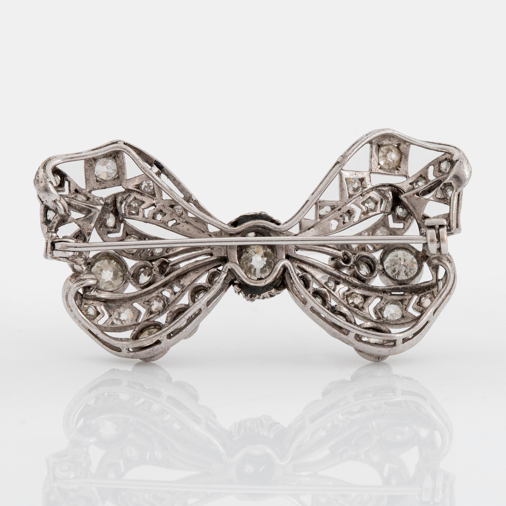 A silver bow brooch set with old-cut diamonds.