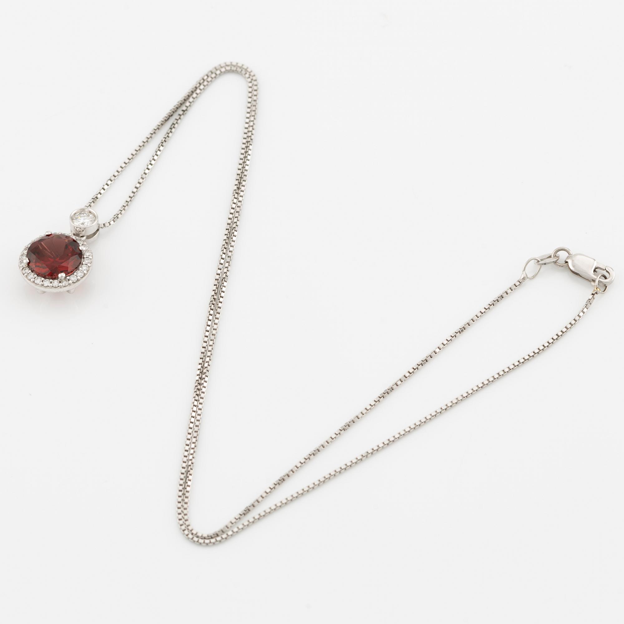 Pendant with a chain in 18K gold set with a faceted garnet and round brilliant-cut diamonds.