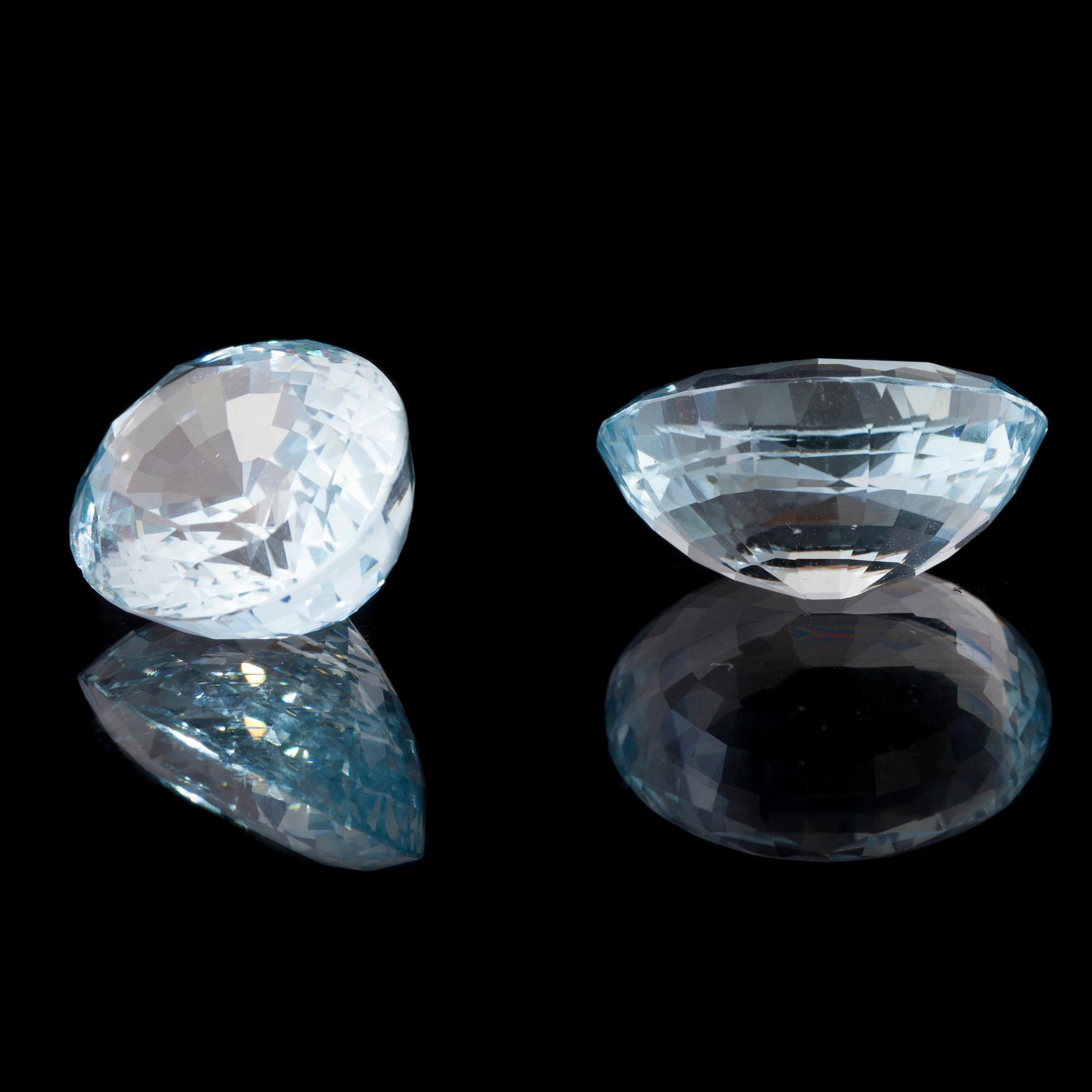 AKVAMARIN, 2 st, oval fasettslipning. Vikt totalt ca 26,93 ct.