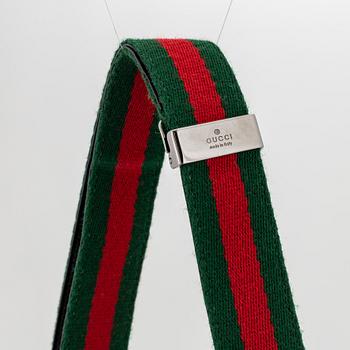 Gucci, a black, patent leather handbag.